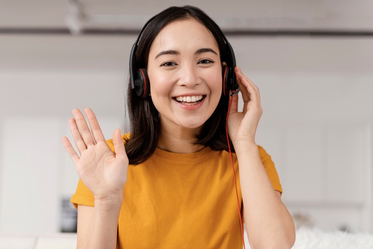 A woman smiling on a video call, wearing a headset